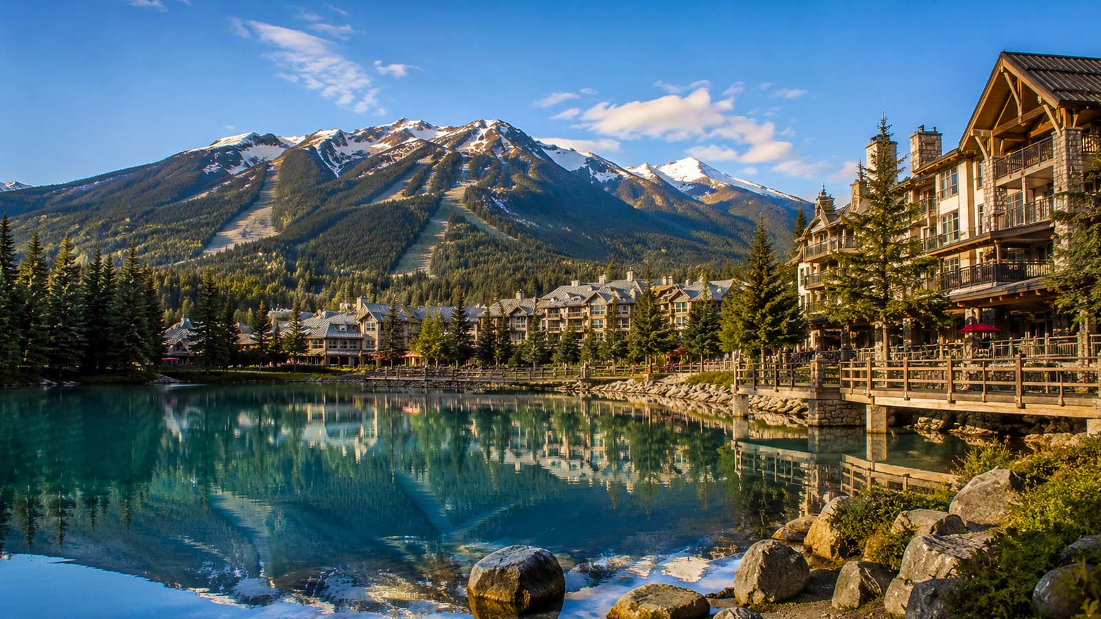 Lakeside resort buildings with mountain reflections in Whistler